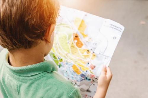 A small child looks at a coloured map.