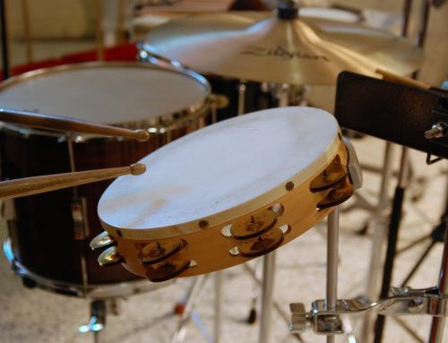 Some drums and a tambourine being hit with sticks.