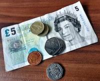 Some British coins on a £5 note.