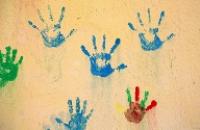 Children's handprints made of different colours of paint.