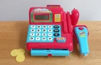 A plastic toy till with pretend money.