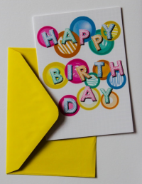 A birthday card beside a yellow envelope.