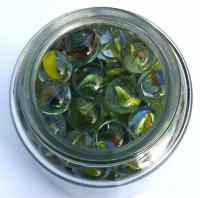 An open jar viewed from the top, filled with marbles.