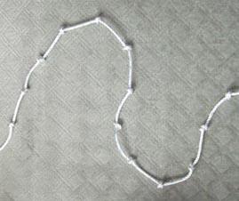 A piece of string knotted at equal intervals along the string to make 12 sections.
