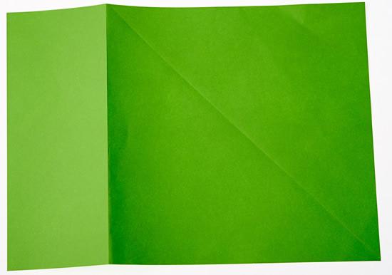 A piece of paper with the top right corner folded over until the right-hand edge meets the bottom edge. It is also folded down the left-hand side, where the top edge ends when it is folded.