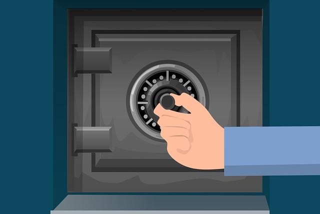 A metal safe with a hand turning the dial.