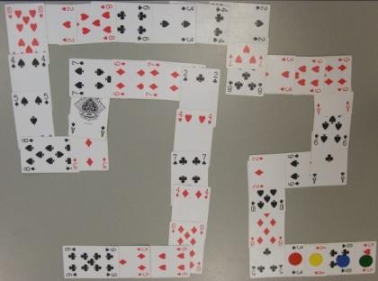 A deck of cards without Jacks, Queens and Kings, which is arranged face-up in a snake-like pattern, so it forms a chain of cards which have their ends connected and bending in some places.