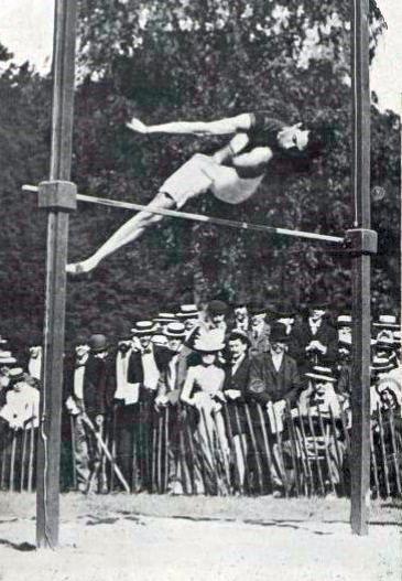 Irving Baxter jumping sideways over the bar in the high jump.
