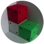Two dice on the ground and one die stacked on top of another, making an L-shape.