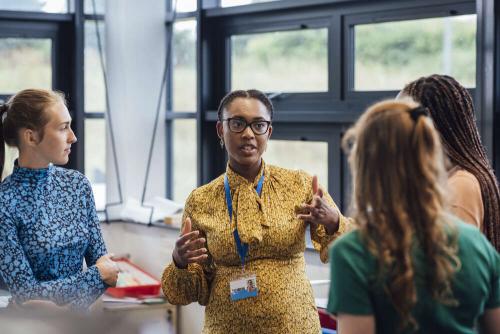 Four professional women standing in a circle and having a discussion.