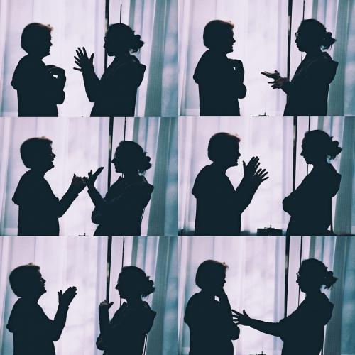 Different silhouette photographs of the same two people talking.
