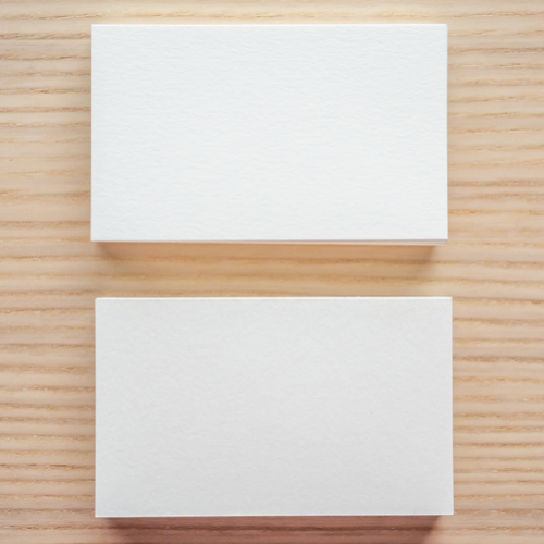 Two white rectangles on a wooden background, arranged like an equals sign.