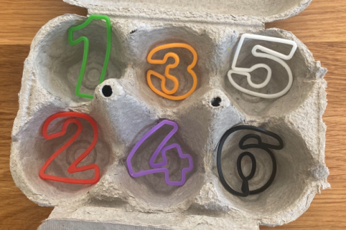An eggbox with plastic numbers 1, 2, 3, 4, 5, 6 in the six empty sections.
