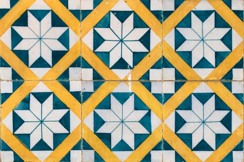 White, green and yellow tiles in a pattern of squares and hexagons.