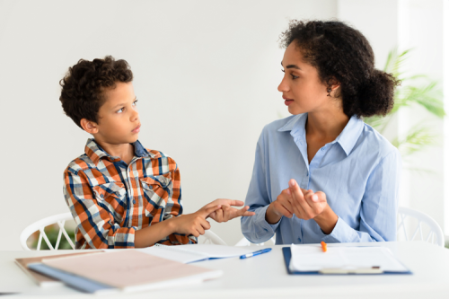 A student and teacher talking and counting on their fingers.