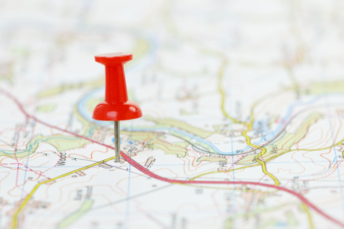 A red pin in a paper map.