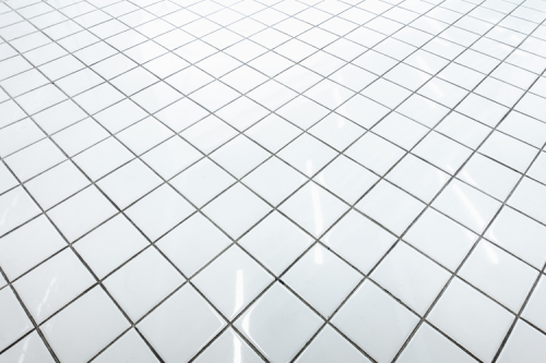 A floor of white tilted square tiles.